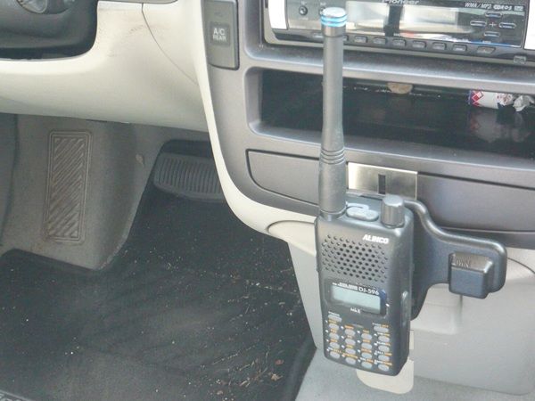 Alinco EBC-6 portofoonhouder gemonteerd in een personenauto met daaraan een portofoon bevestigd