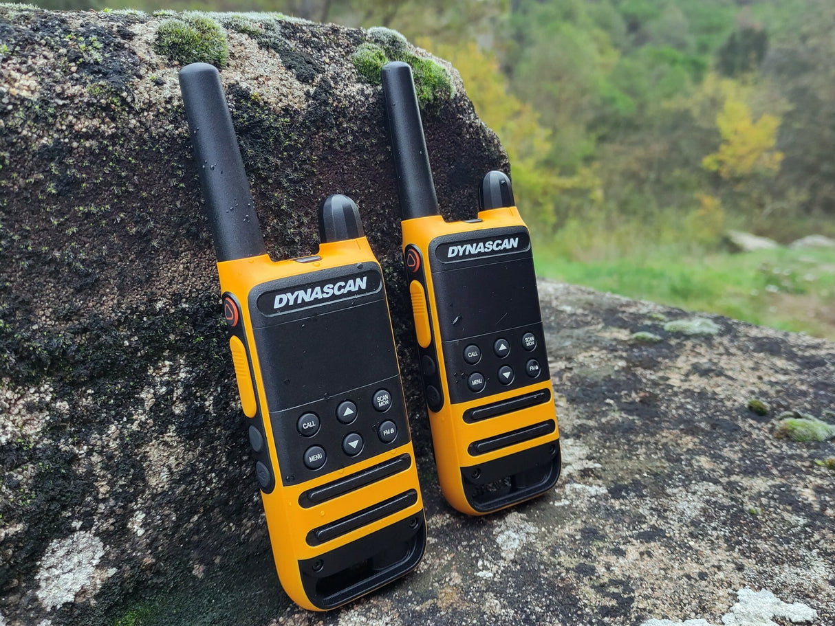 Dynascan P19 twee PMR446 walkie talkies buiten tegen een steen