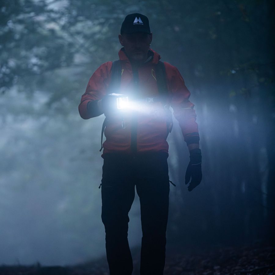 man in het donker die schijnt met de zaklamp op de Midland ER-300Pro noodradio