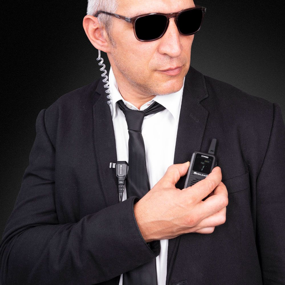 Midland 777Pro in gebruik door een beveiliger met een microfoon en oortje met discrete airtube