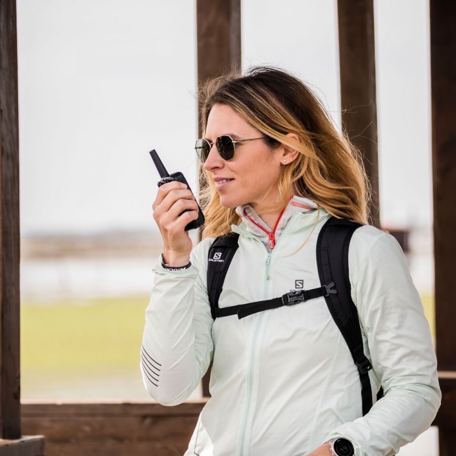 Midland C1464.01 XT50 Pro PMR446 portofoon in gebruik door een vrouw tijdens haar buiten activiteit