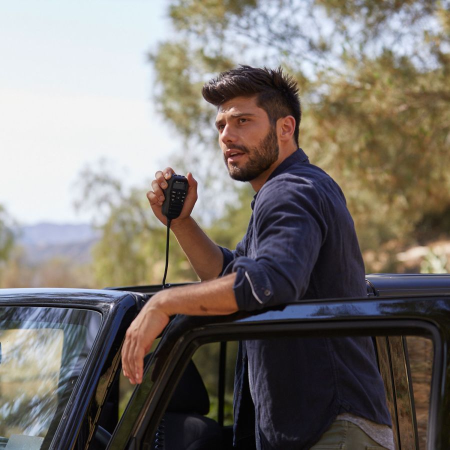 Midland M5 CB-transceiver met multifunctionele handmicrofoon, onderweg gebruikt door een man