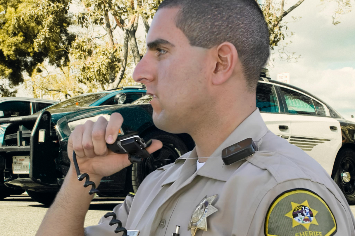 Amerikaanse politie agent met een lapel microfoon aan een lapel retractor
