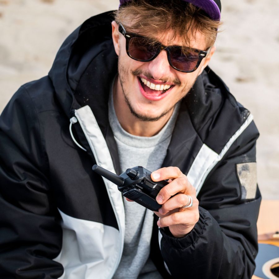 Midland XT-70 Pro portofoon waarmee een jongeman communiceert