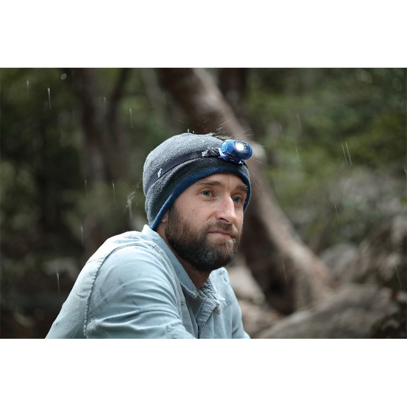 Favour H1411 hoofdlamp gedragen over een muts door een man die in de buitenlucht is