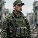 Man in camouflage kleding met portofoon en keelmicrofoon