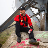 Zittende man die een midland ER300 Pro noodradio in zijn hand heeft