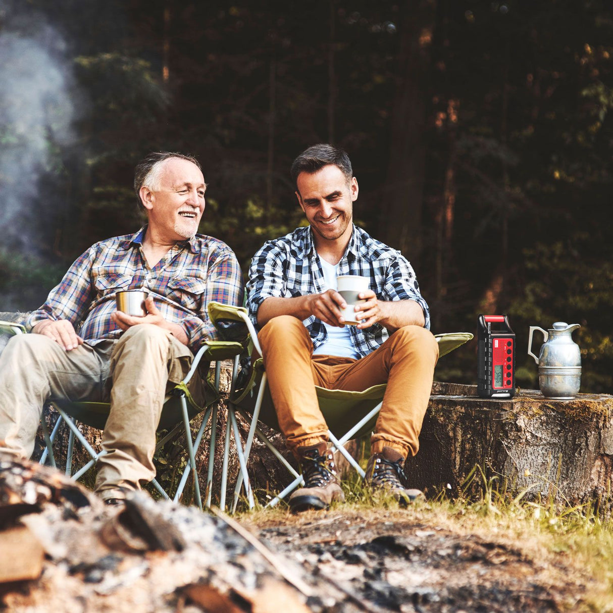 Midland ER300 noodradio in gebruik door twee mannen die aan het relaxen zijn bij het kampvuur