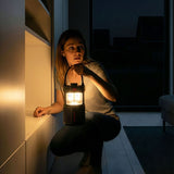 Vrouw die in het donker met een Midland C1717 ER-led lantaarn in haar hand loopt 